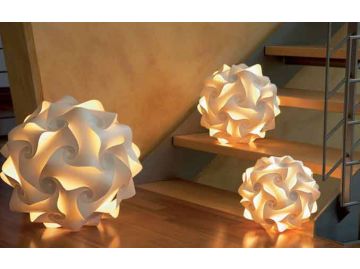 Drei leuchtende Sphere Lichtobjekte mit wirbelnden geometrischen Mustern sind auf Stufen und einem Holzboden im Innenbereich platziert und präsentieren exquisite handgefertigte Leuchten.
