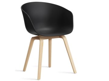 Der About A Chair AAC22 inkl.. Filzgleiter (schwarz) von HAY ist ein moderner schwarzer Kunststoffstuhl mit hellen Holzbeinen, der skandinavisches Design widerspiegelt und auf weißem Hintergrund abgebildet ist.