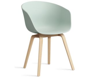 Der About A Chair AAC22 inkl.. Filzgleiter in dusty mint zeichnet sich durch einen geschwungenen Kunststoffsitz und Holzbeine aus - dieser moderne Designersessel von HAY Möbel hebt sich von einem weißen Hintergrund ab.