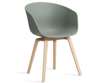 Der About A Chair AAC22 inkl.. Filzgleiter (Herbstgrün) verfügt über eine geschwungene grüne Sitzfläche und helle Holzbeine, inspiriert vom Designerstuhl Hee Welling AAC22 Armlehnenstuhl, der vor einem weißen Hintergrund gezeigt wird.