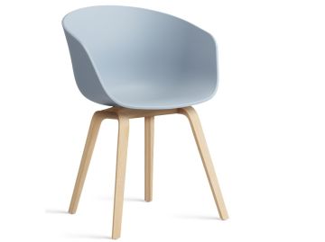 Der About A Chair AAC22 inkl.. Filzgleiter verfügt über einen geschwungenen Kunststoffsitz und helle Holzbeine. Er vereint Komfort und Stil, inspiriert vom Armlehnenstuhl AAC22, der hier vor einem schlichten weißen Hintergrund gezeigt wird.