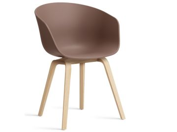 Der About A Chair AAC22 inkl.. Filzgleiter verfügt über einen geschwungenen Kunststoffsitz und helle Holzbeine. Er vereint Komfort und Stil, inspiriert vom Armlehnenstuhl AAC22, der hier vor einem schlichten weißen Hintergrund gezeigt wird.