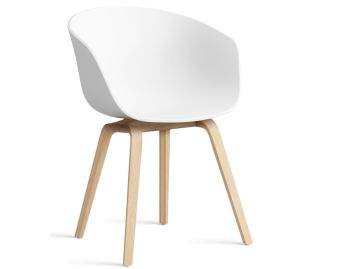 Der About A Chair AAC22 inkl.. Filzgleiter (weiß) zeichnet sich durch eine moderne weiße, geschwungene Sitzfläche und helle Holzbeine aus, die vor einem weißen Hintergrund stehen.