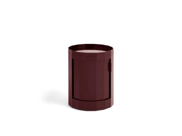 Ein burgunderroter, zylindrischer Facet Cabinet Low steht auf weißem Grund - eine elegante HAY-Aufbewahrungslösung und mobiles Element in einem.