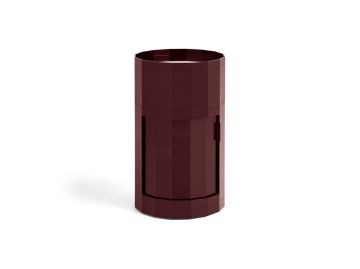Ein burgunderroter, zylindrischer, moderner Facettenschrank hoch mit einer kleinen Tür und facettiertem geometrischen Design - perfekt als stilvolles Aufbewahrungsmöbel für jeden Raum.