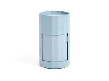 Misty blue Facet Cabinet high, ein zylindrischer Schrank mit facettiertem Design und einer kleinen Seitentür für einfachen Zugang.
