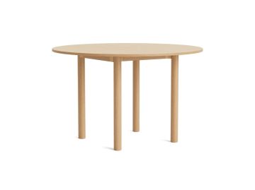 Der Annex-Table-Round Ø120 cm (eiche, eiche) ist ein runder Holztisch mit vier Beinen aus FSC-zertifizierter Eiche auf weißem Grund.