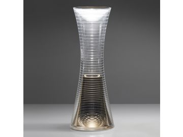 Eine hohe, sanduhrförmige Glasvase mit weißen Streifen und einem dunklen Sockel auf grauem Grund erinnert an das schlichte Design der Come together Kupfer.