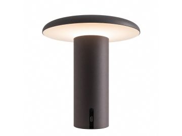 Die Takku Tischleuchte ist eine moderne, kabellose Tischlampe von Artemide in Mattschwarz. Ihre zylindrische Form und die breite, flache Oberseite strahlen ein sanftes weißes Licht aus; am Sockel befindet sich ein kleiner Ladeanschluss.
