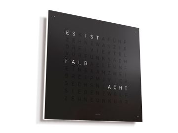 Die QLOCKTWO EARTH 45 DE (black pepper) ist eine schwarze, quadratische Wortuhr mit beleuchteten Buchstaben in der Mitte - eine Wanduhr mit ikonischem Design, die moderne Eleganz in jeden Raum bringt.