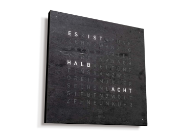 Text auf einer dunklen Wand mit HALB, das in schwachen Buchstaben leuchtet und an die QLOCKTWO EARTH 45 CREATOR'S EDITION (DE) Metamorphite Korpus schwarz erinnert.