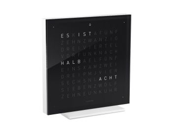 Die QLOCKTWO EARTH 13.5 PURE (DE) in schwarzem Eistee zeigt "HALB ACHT" mit scharfen weißen Buchstaben, die auf dem modernen schwarzen, quadratischen Zifferblatt leuchten.