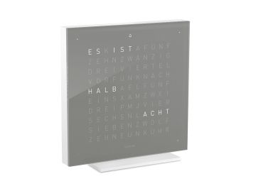 Eine quadratische, graue QLOCKTWO EARTH 13.5 PURE (DE) (Earl Grey Tea) Uhr von Zeitdesign zeigt auf ihrem Zifferblatt in Leuchtbuchstaben "HALB ACHT".
