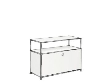 Das USM Haller Beistellmöbel mit 1 Klappe ist ein weißer Beistelltisch aus Metall mit einer offenen oberen Ablage und einem abschließbaren geschlossenen Fach darunter.