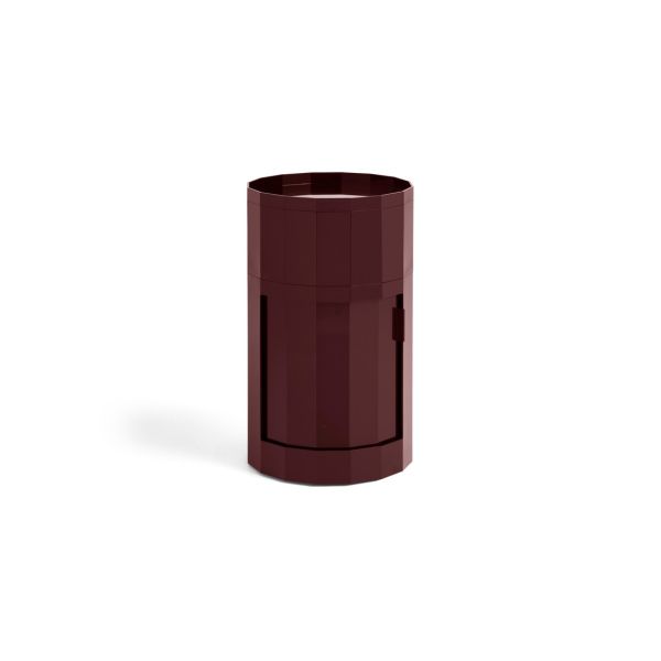Ein burgunderroter, zylindrischer, moderner Facettenschrank hoch mit einer kleinen Tür und facettiertem geometrischen Design - perfekt als stilvolles Aufbewahrungsmöbel für jeden Raum.