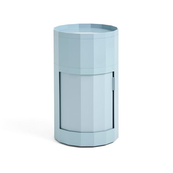 Der Facet Cabinet high von HAY ist ein hellblaues, zylindrisches Aufbewahrungsmöbel mit facettiertem Design und einer Fronttür - ideal als stilvolles Aufbewahrungsmöbel für moderne Interieurs.