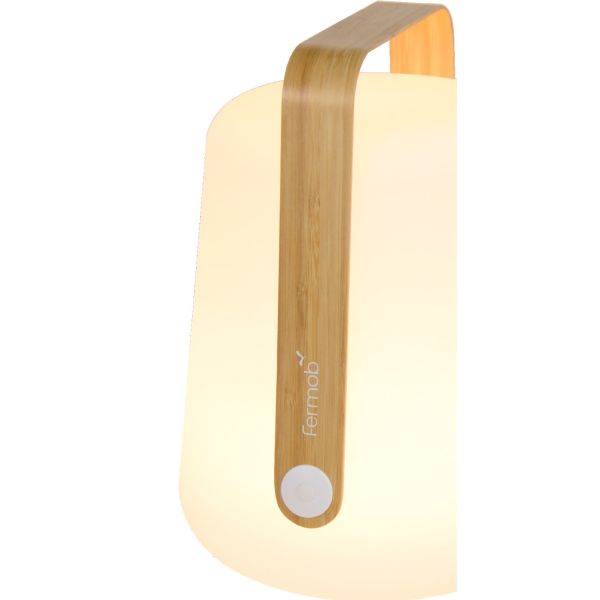 Die BALAD LAMPE BAMBOO H25 hat einen Bambusgriff, einen weißen, abgerundeten Korpus und ein fermob-Logo - für einen nachhaltigen Look als Teil einer umweltfreundlichen Edition.