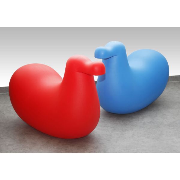 Zwei Dodo-Skulpturen, eine rote und eine blaue, sitzen auf einer grauen Oberfläche mit Farbverlaufshintergrund - perfekt, um jedem Kinderzimmer einen verspielten Charme zu verleihen.