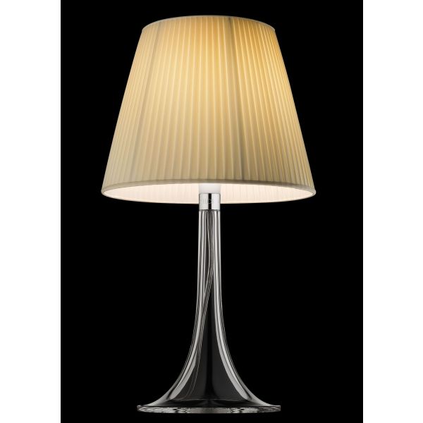 Die Miss K (Gewebe) ist eine moderne Tischleuchte, die vom Flos-Design von Philippe Starck inspiriert ist. Sie hat einen plissierten beigen Lampenschirm mit einem Sockel aus klarem Glas und wird vor einem schwarzen Hintergrund elegant beleuchtet.
