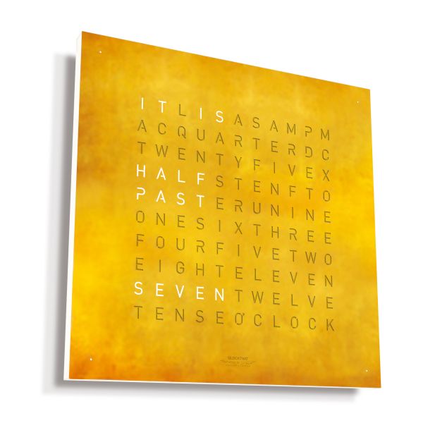 Die gelbe QLOCKTWO EARTH 45 CREATOR'S EDITION (DE) zeigt in weißer Schrift "It is half past seven" inmitten anderer ausgegrauter Wörter als einzigartige typografische Wanduhr.
