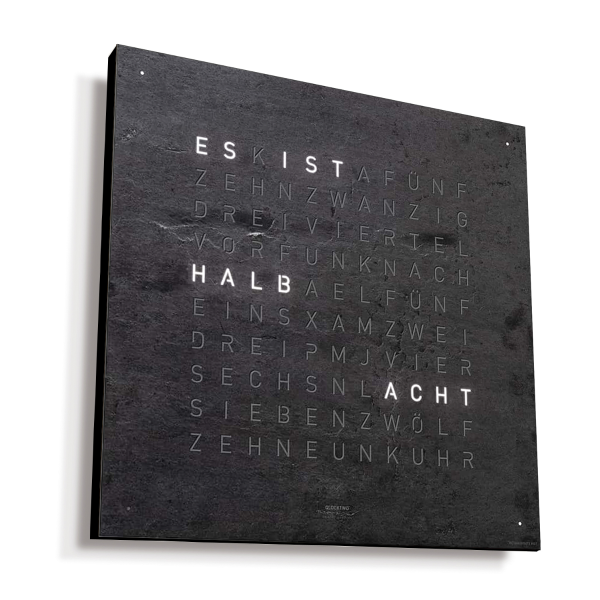 Text auf einer dunklen Wand mit HALB, das in schwachen Buchstaben leuchtet und an die QLOCKTWO EARTH 45 CREATOR'S EDITION (DE) Metamorphite Korpus schwarz erinnert.