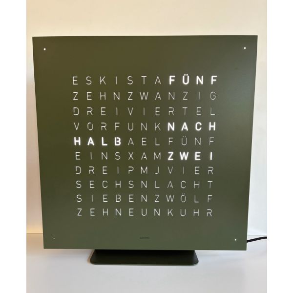 Die QLOCKTWO EARTH 45 COLOR EDITION Set OLIVE GREEN (DE) ist eine quadratische deutsche Wortuhr, die die Zeit mit beleuchteten Worten auf einem olivgrünen Zifferblatt anzeigt.