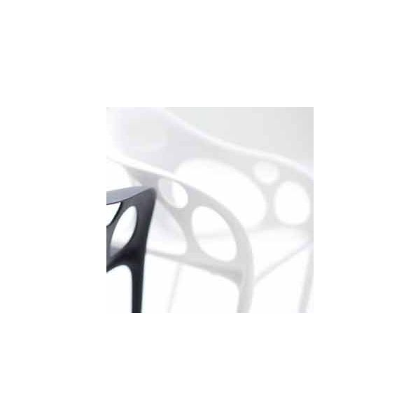Nahaufnahme des Supernatural Armchair (weiß) von Moroso, entworfen von Ross Lovegrove, mit kreisförmigem Ausschnitt, einem schwarzen Stuhl im Vordergrund und einem unscharfen weißen Stuhl im Hintergrund.