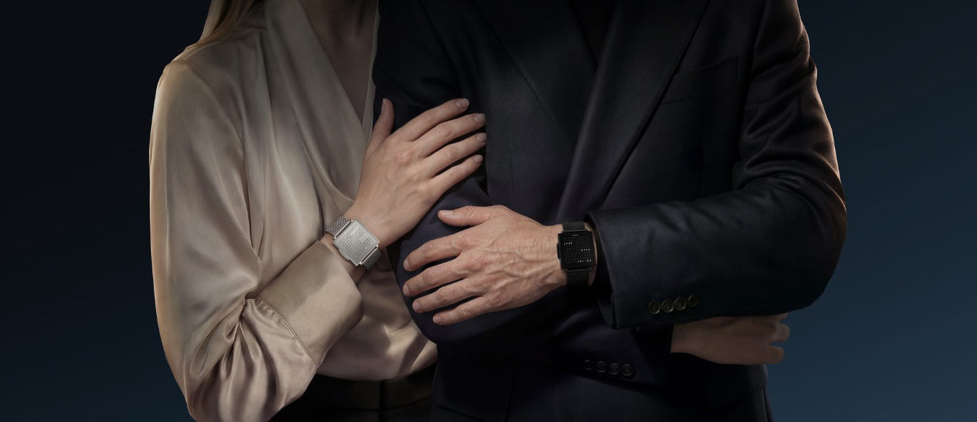 Zwei Personen tragen die Qlocktwo W Armbanduhr, einmal in Black Steel und einmal in Fine Steel
